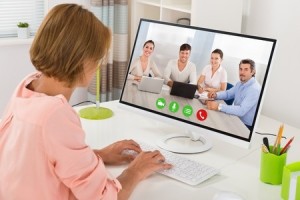 45696173 - young woman videoconferencing with colleagues on computer at desk