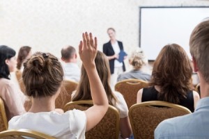 44777147 - photo of listener raising hand to ask question during seminar